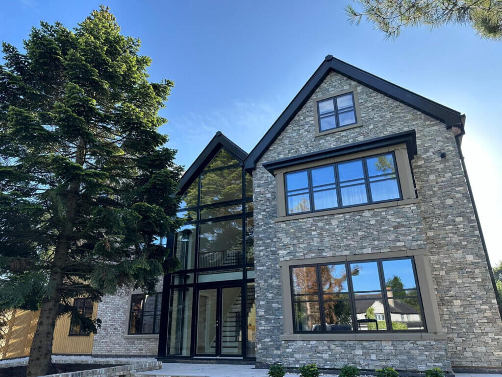 Exterior of The Gables self-build home featuring SIP construction, vaulted rooflines, and large glazed openings.